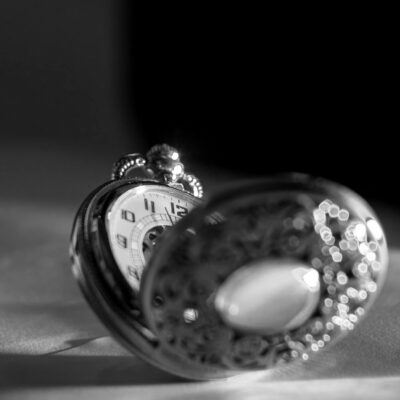 Black and white close-up of an antique pocket watch showcasing intricate craftsmanship and timeless elegance.