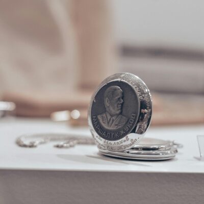 Close-up of a vintage silver pocket watch in a sophisticated still life setting, capturing timeless elegance.